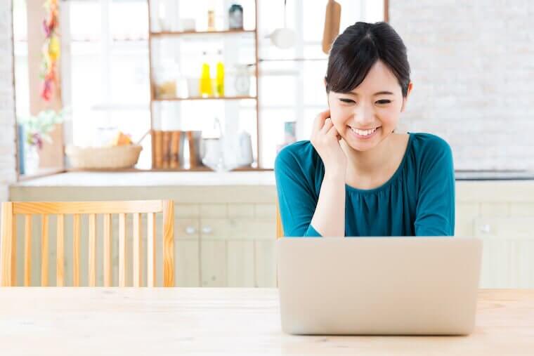 部屋でパソコンを見る女性