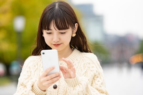 Ravit（ラビット）の口コミ・評判をスマホでチェックする女性